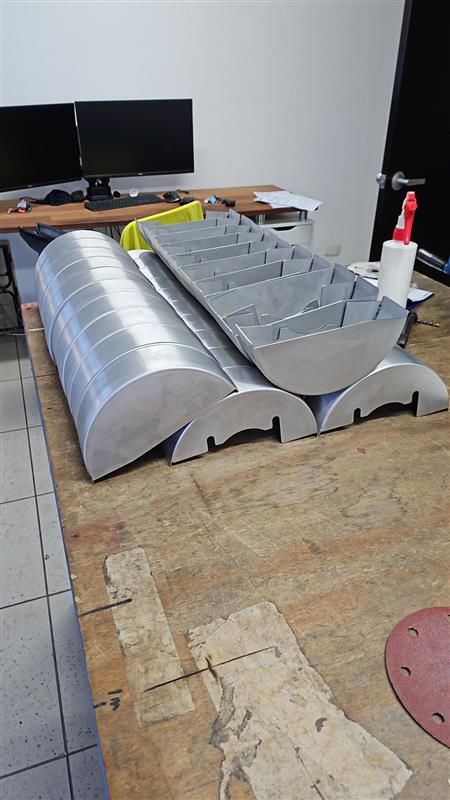 Batch of formed metal components on a workbench